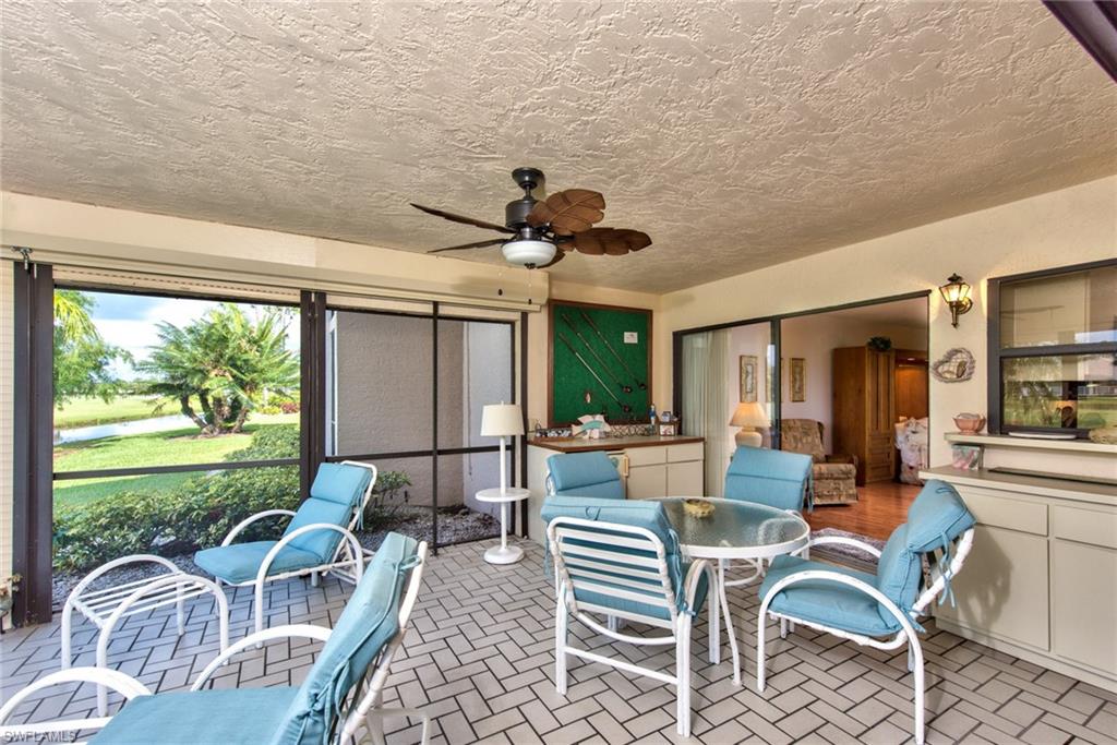 14730 Eagle Ridge Drive, Unit 122 Fort Myers, FL 33912 - Photo 9 of 27 a living room with furniture a chandelier and a large window