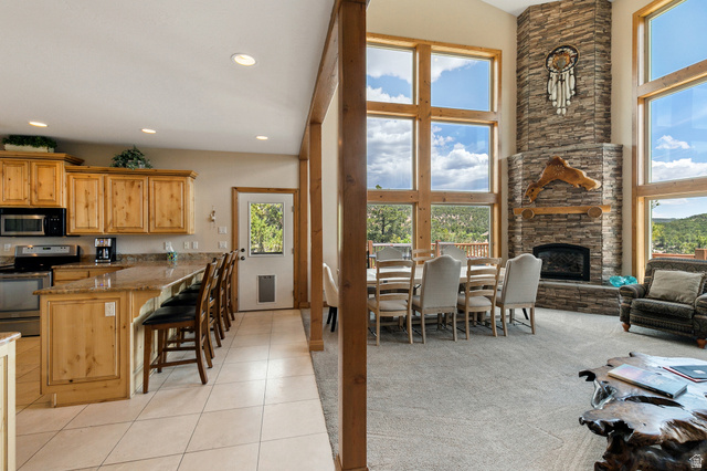 755 South Zion Ridge Drive Orderville, UT 84758 - Photo 39 of 84 Kitchen featuring stainless steel appliances, a breakfast bar area, dark stone countertops, light colored carpet, and a fireplace