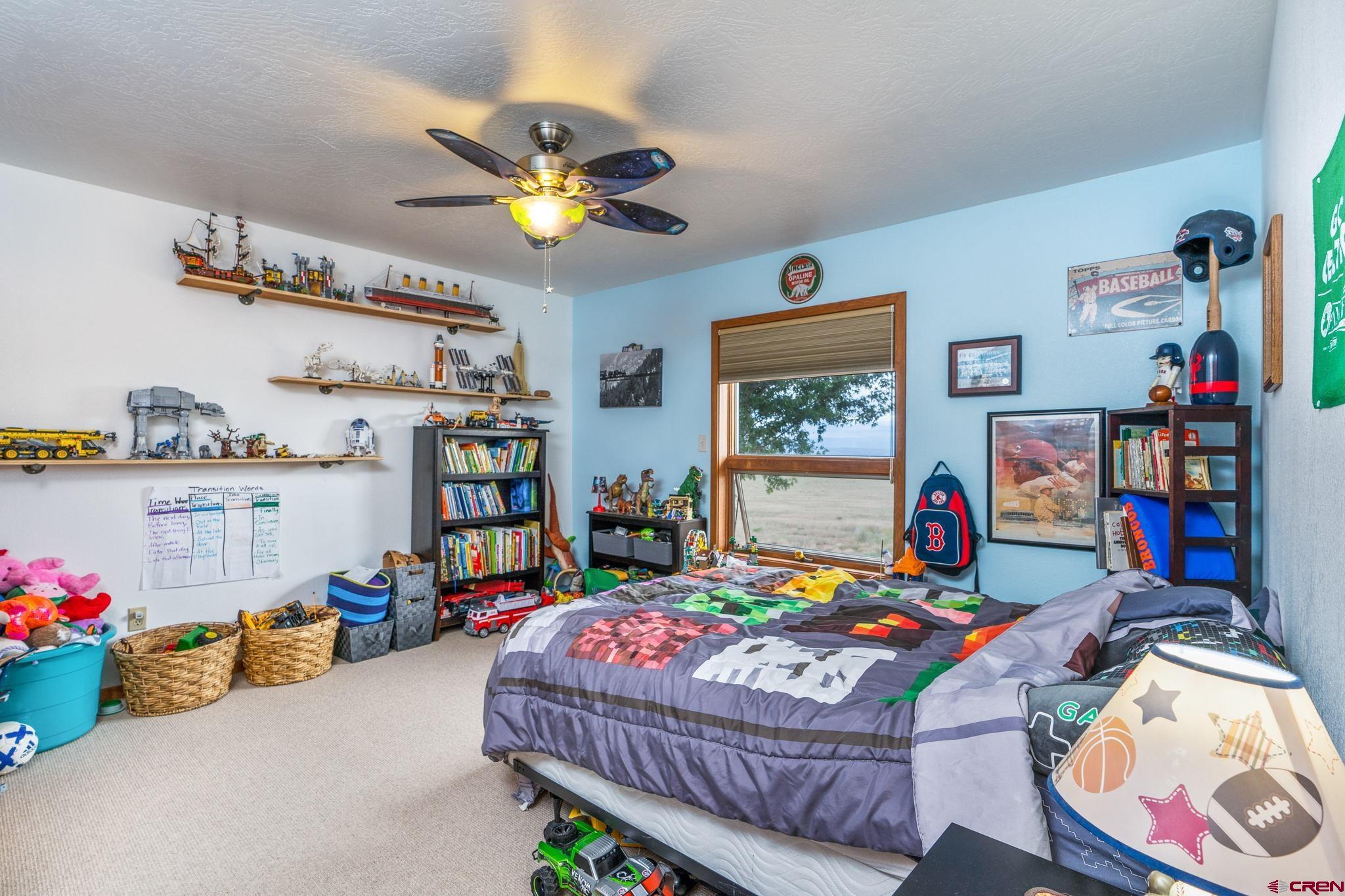 12190 Road 16 Cortez, CO 81321 - Photo 19 of 31 a bedroom with a bed a window and dresser