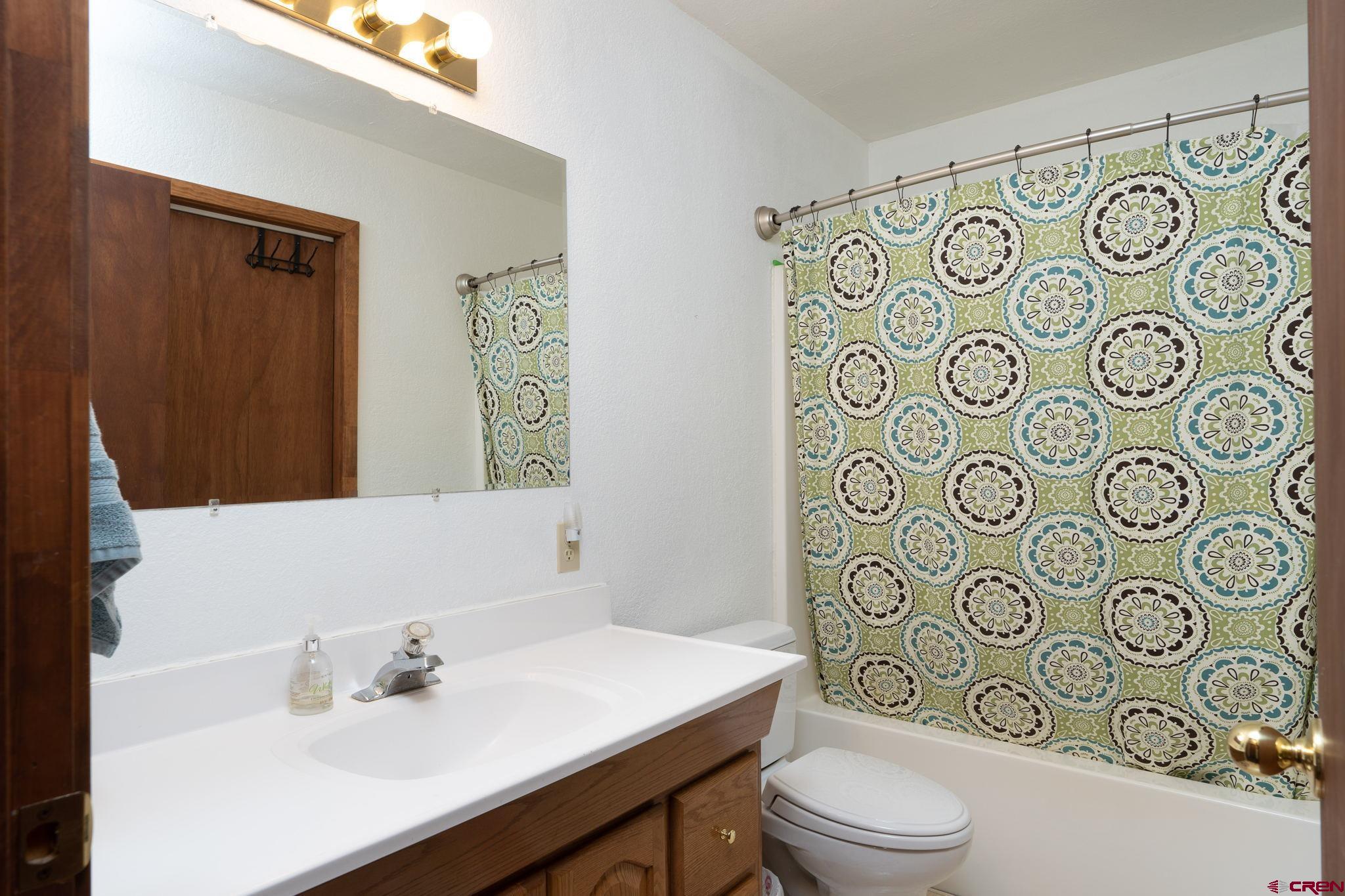 12190 Road 16 Cortez, CO 81321 - Photo 23 of 31 a bathroom with a sink a toilet and shower curtain