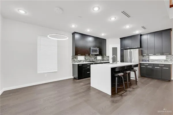 a kitchen with a sink cabinets and wooden floor