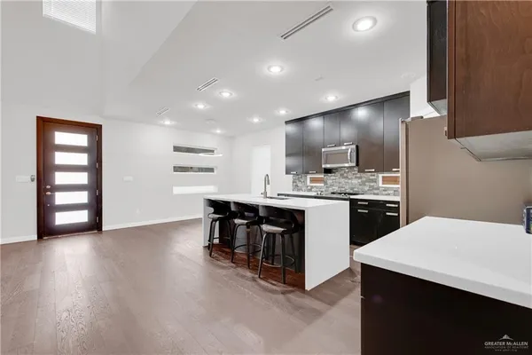 a kitchen with stainless steel appliances a refrigerator and a stove top oven