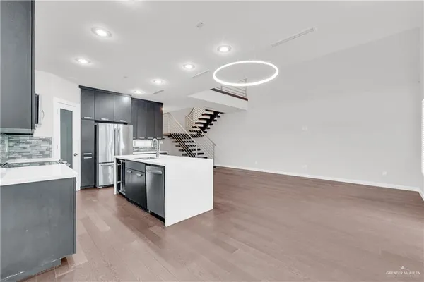 a large kitchen with stainless steel appliances kitchen island a large counter top and oven