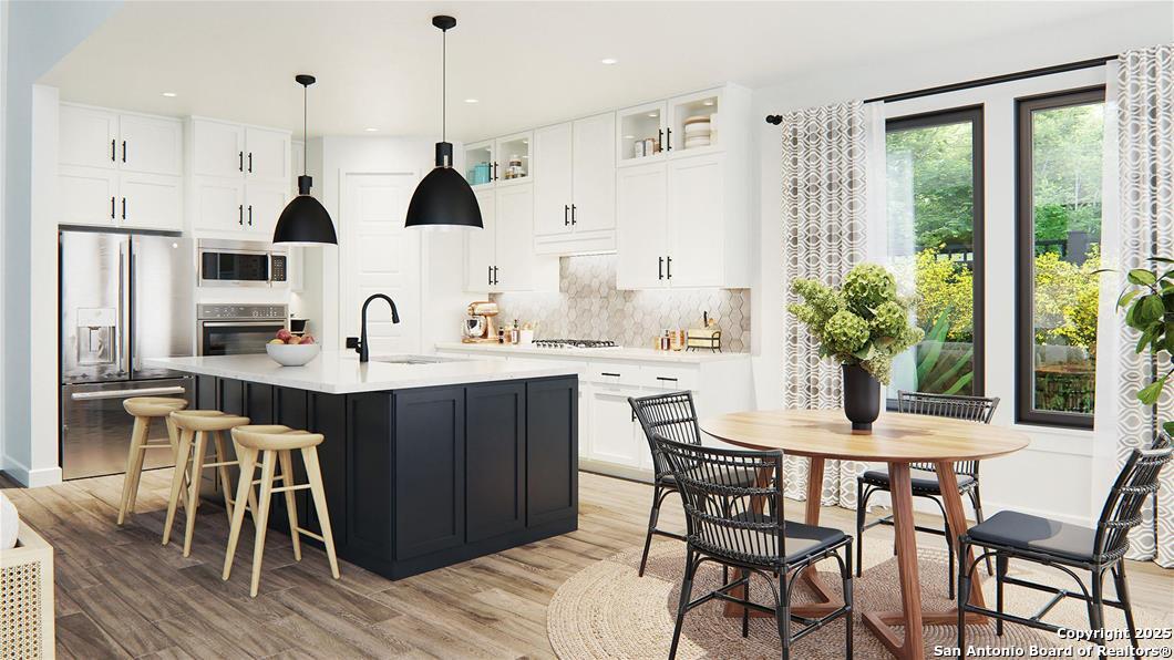 105 Tortuga Boerne, TX 78006 - Photo 4 of 7 a kitchen with stainless steel appliances kitchen island granite countertop a table and chairs in it