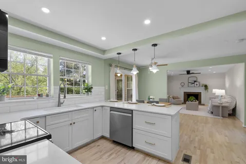 a large white kitchen with a large window and stainless steel appliances