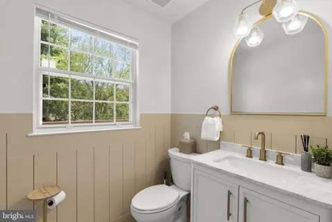 a bathroom with a sink a toilet and a window
