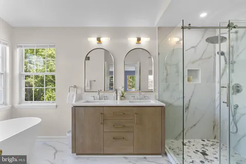 a bathroom with a double vanity sink mirror and shower
