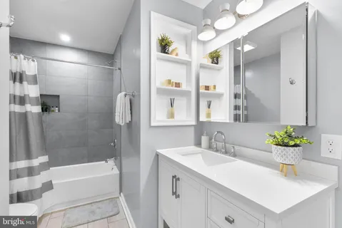a bathroom with a bathtub sink and mirror