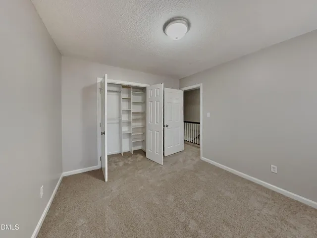 an empty room with a walk in closet and closet