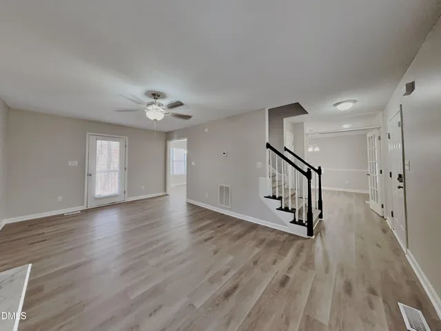 a view of a livingroom with wooden floor and a ceiling fan