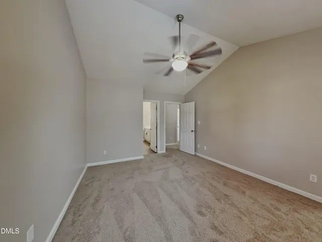 an empty room with a ceiling fan and a window