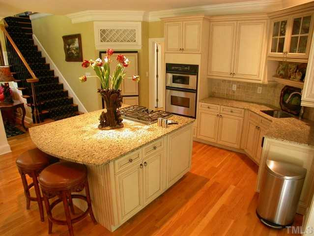 1528 Tradescant Court Raleigh, NC 27613 - Photo 13 of 25 Another view of gourmet kitchen with eat at bar, granite countertops, and hardwood floors. Kitchen