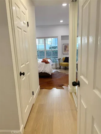 a view of a bedroom with wooden floor and windows