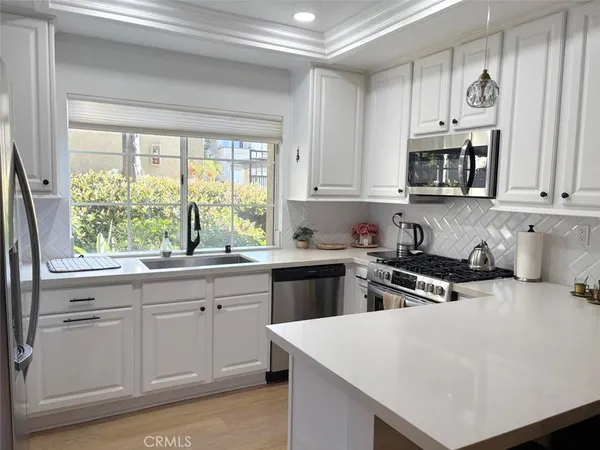 a kitchen with stainless steel appliances white cabinets and a stove top oven