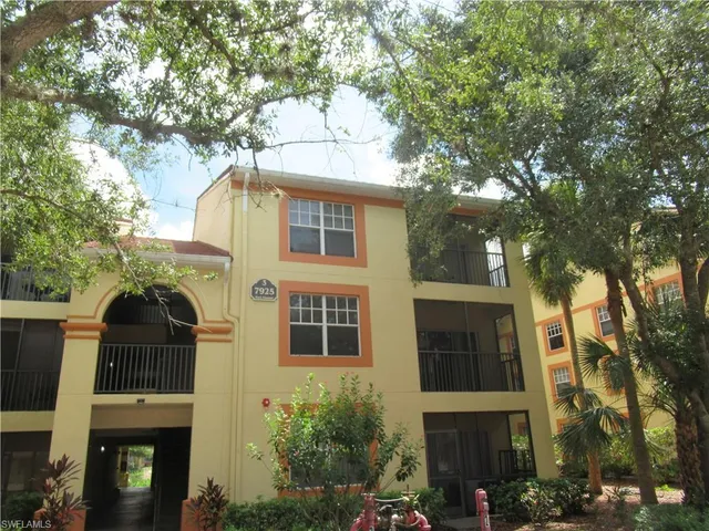 a front view of a house with a tree