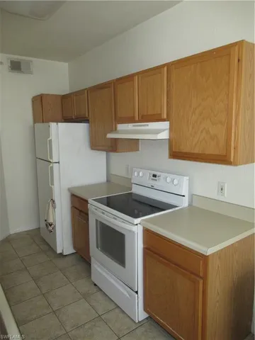 a white stove top oven sitting inside of a kitchen