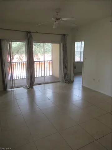 a view of an empty room with glass door and windows