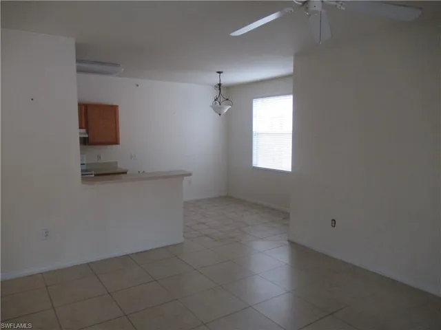 an empty room with windows and cabinet