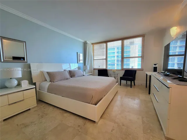 a spacious bedroom with a large bed and a flat screen television