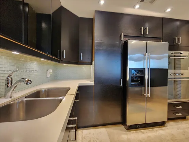 a kitchen with kitchen island a counter top and stainless steel appliances