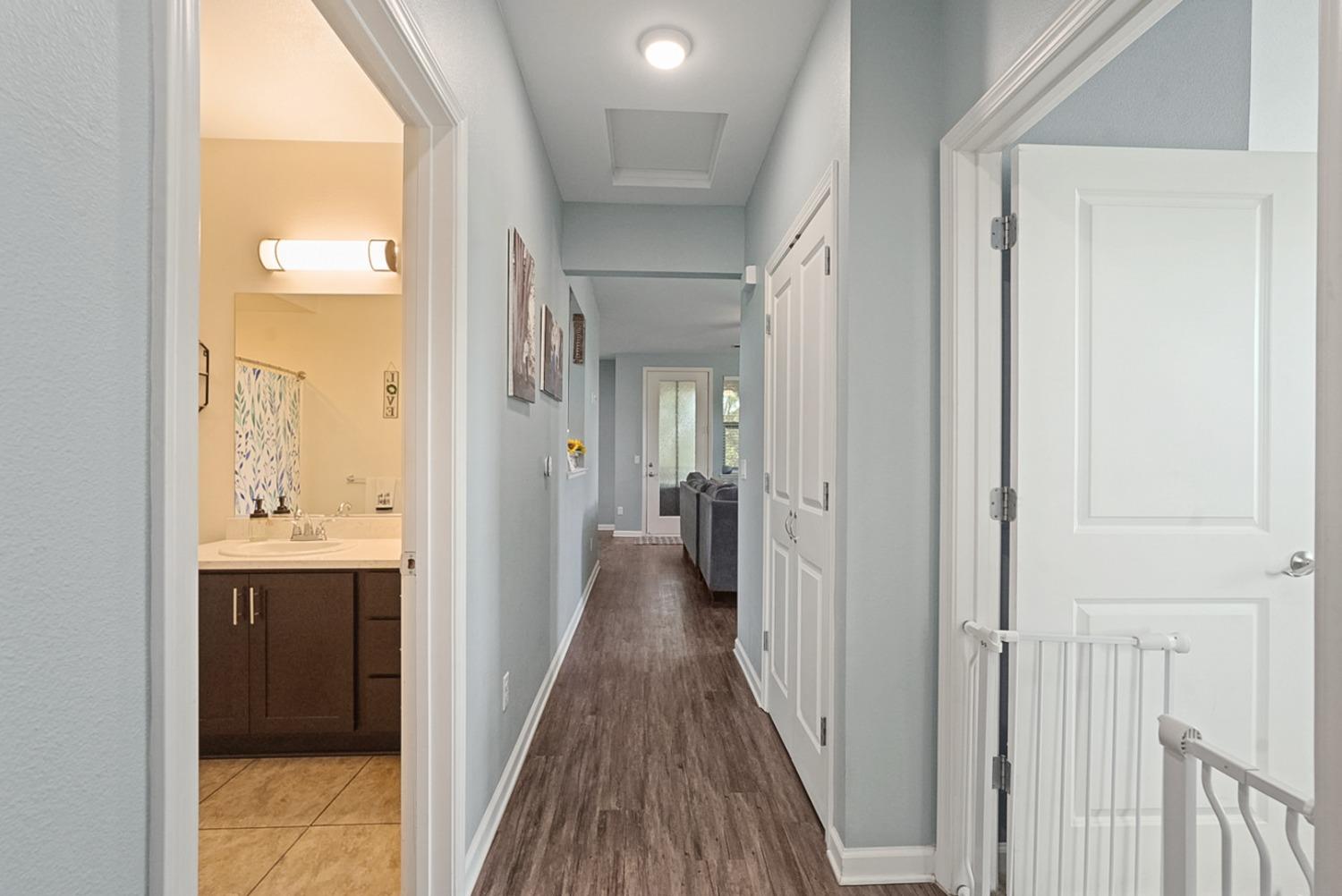140 Ivy Avenue, Unit A5 Patterson, CA 95363 - Photo 17 of 26 a view of a hallway with wooden floor and a bathroom