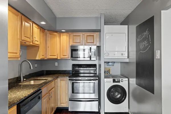 a kitchen with stainless steel appliances granite countertop a sink a stove and cabinets