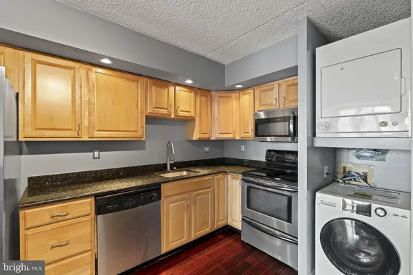 a kitchen with granite countertop cabinets stainless steel appliances and a large window