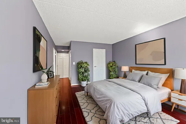 a bedroom with a bed a bookshelf and a flat screen tv