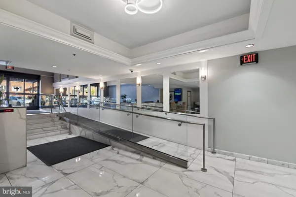 a large white kitchen with lots of counter space and chandelier