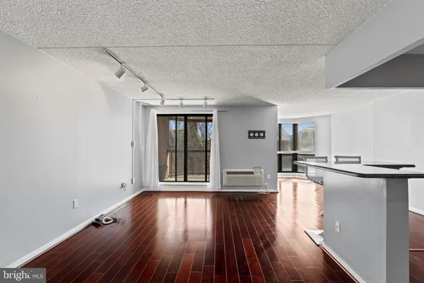 a view of a living room hardwood floor and a window