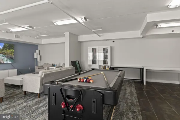 a living room with game table and chairs