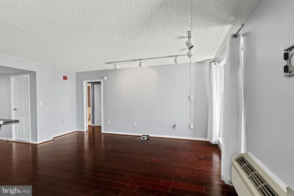 a view of an empty room with wooden floor