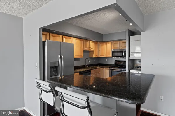 a kitchen with granite countertop a sink counter top space and stainless steel appliances