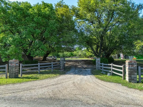 a view of backyard with trees and wooden fence