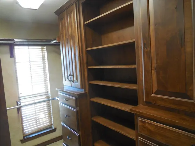 a view of walk in closet with empty racks