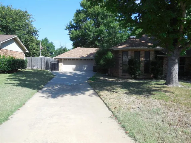 a front view of a house with a yard and shrubs