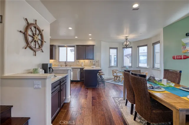 a living room with stainless steel appliances furniture and a kitchen view