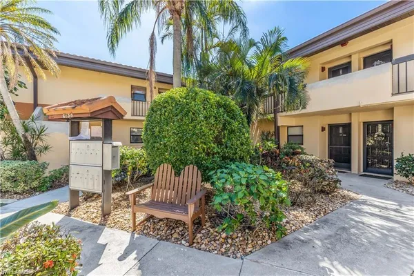 a view of a chair and table in backyard of the house