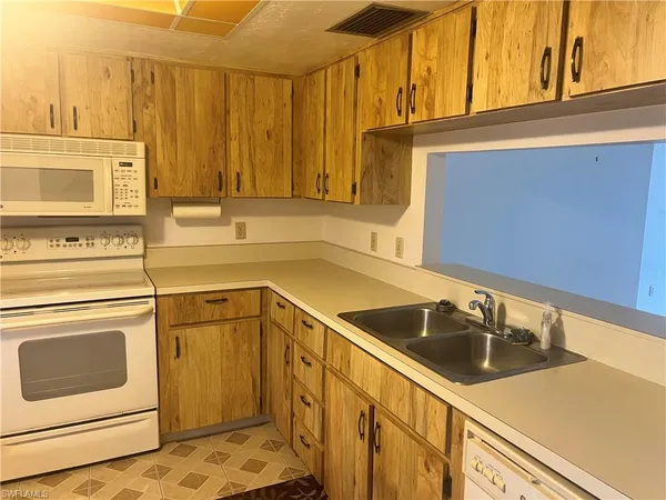 a kitchen with a sink a stove a refrigerator and cabinets