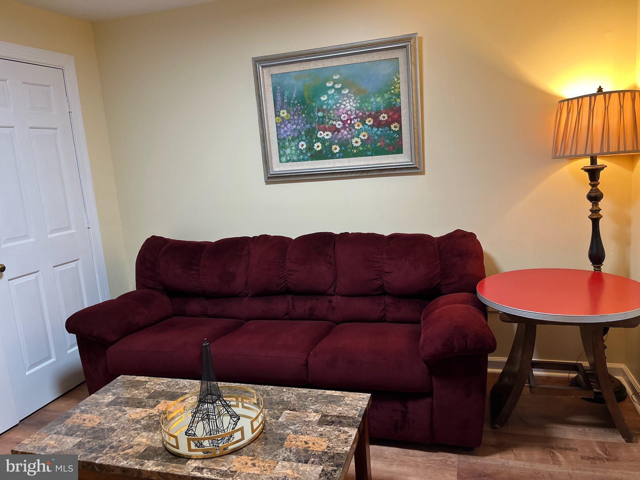 7288 Flaxpool Court Hanover, MD 21076 - Photo 16 of 23 a living room with furniture and a lamp