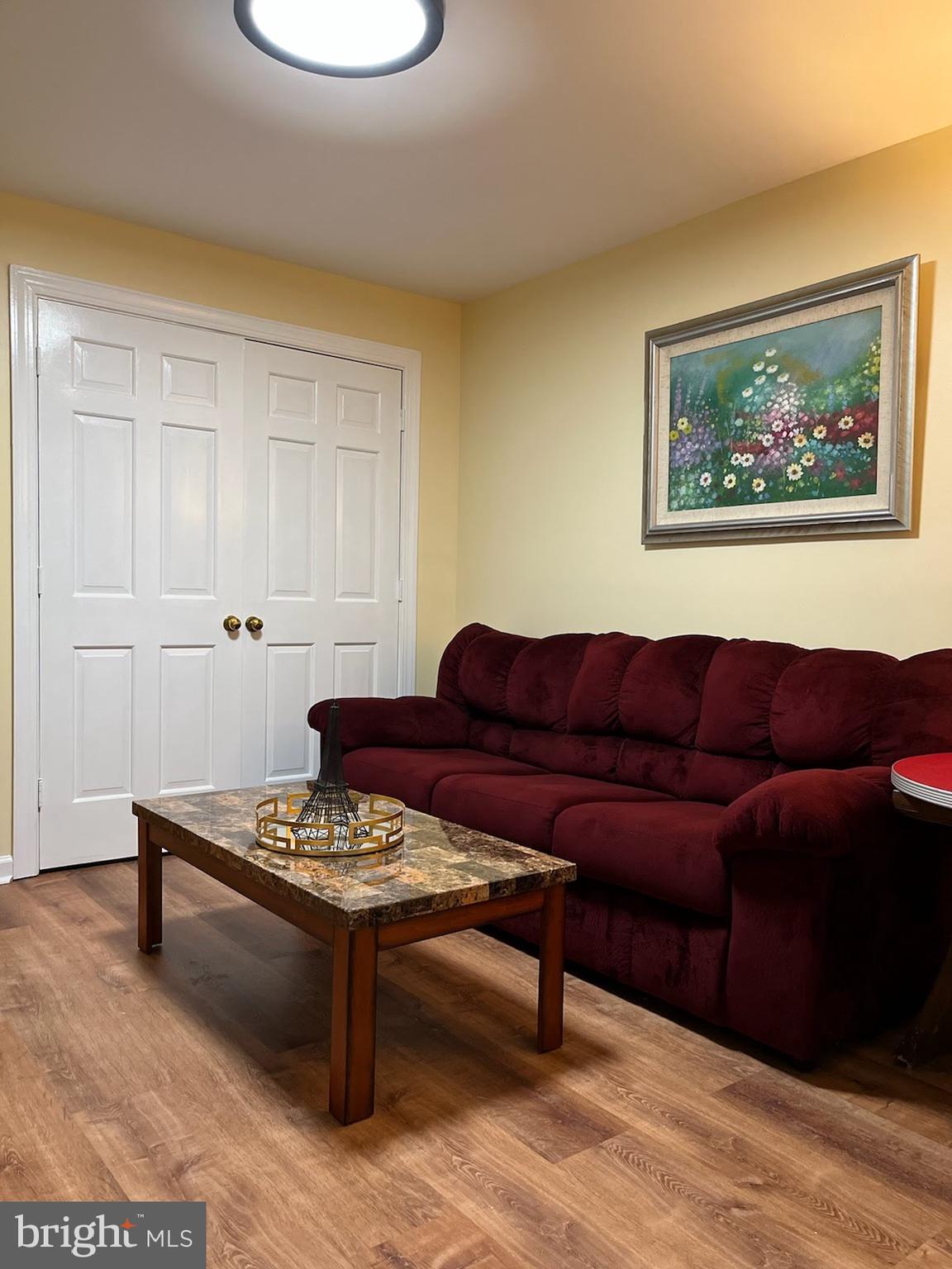7288 Flaxpool Court Hanover, MD 21076 - Photo 17 of 23 a living room with furniture and a wooden floor