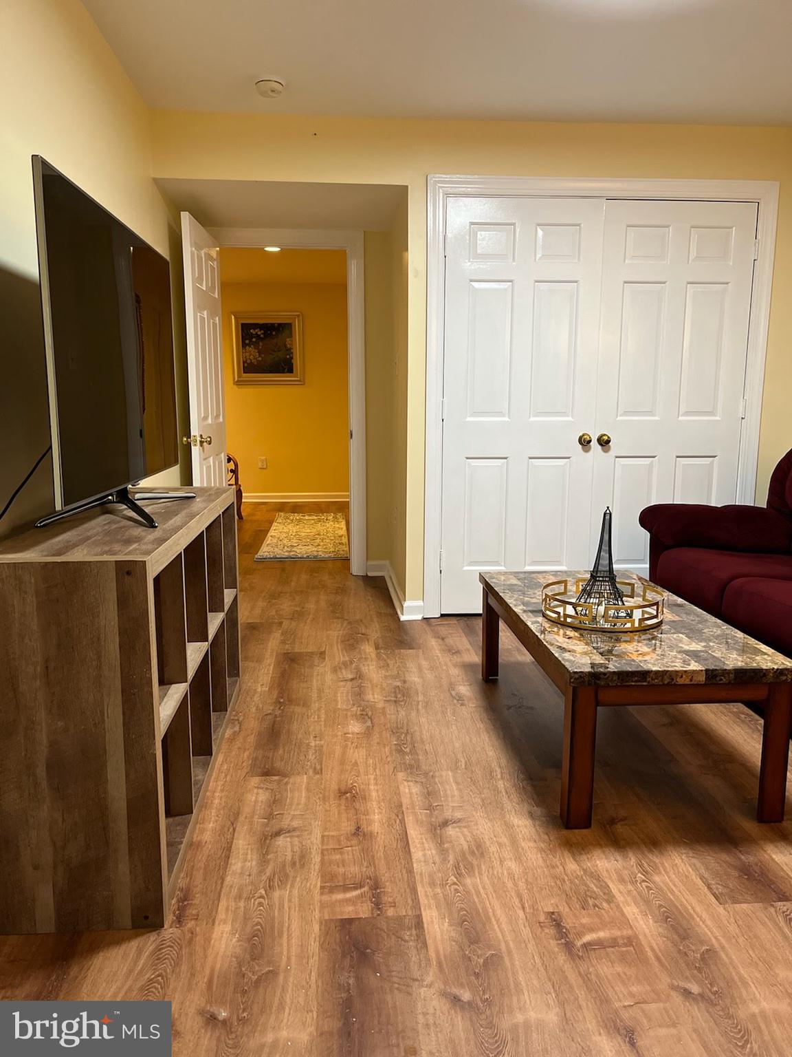 7288 Flaxpool Court Hanover, MD 21076 - Photo 23 of 23 a living room with a couch and a flat screen tv