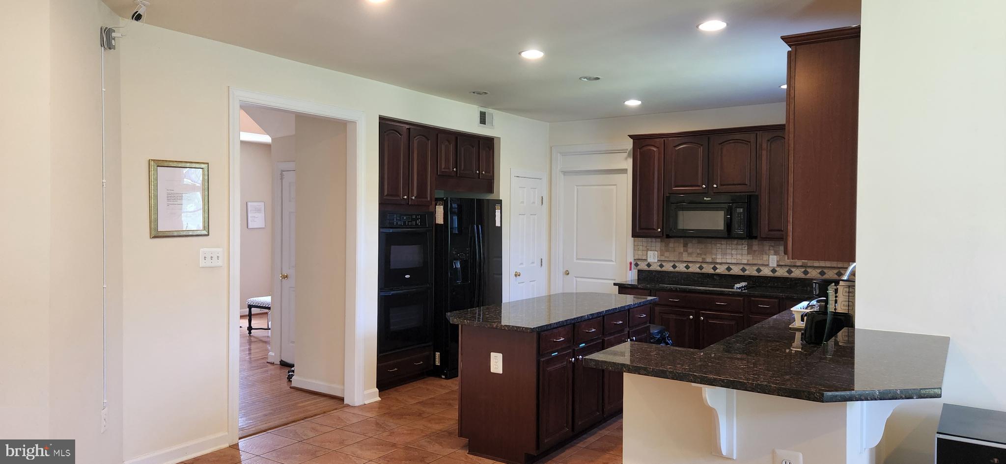 7288 Flaxpool Court Hanover, MD 21076 - Photo 5 of 23 a kitchen with stainless steel appliances granite countertop a refrigerator and a stove top oven