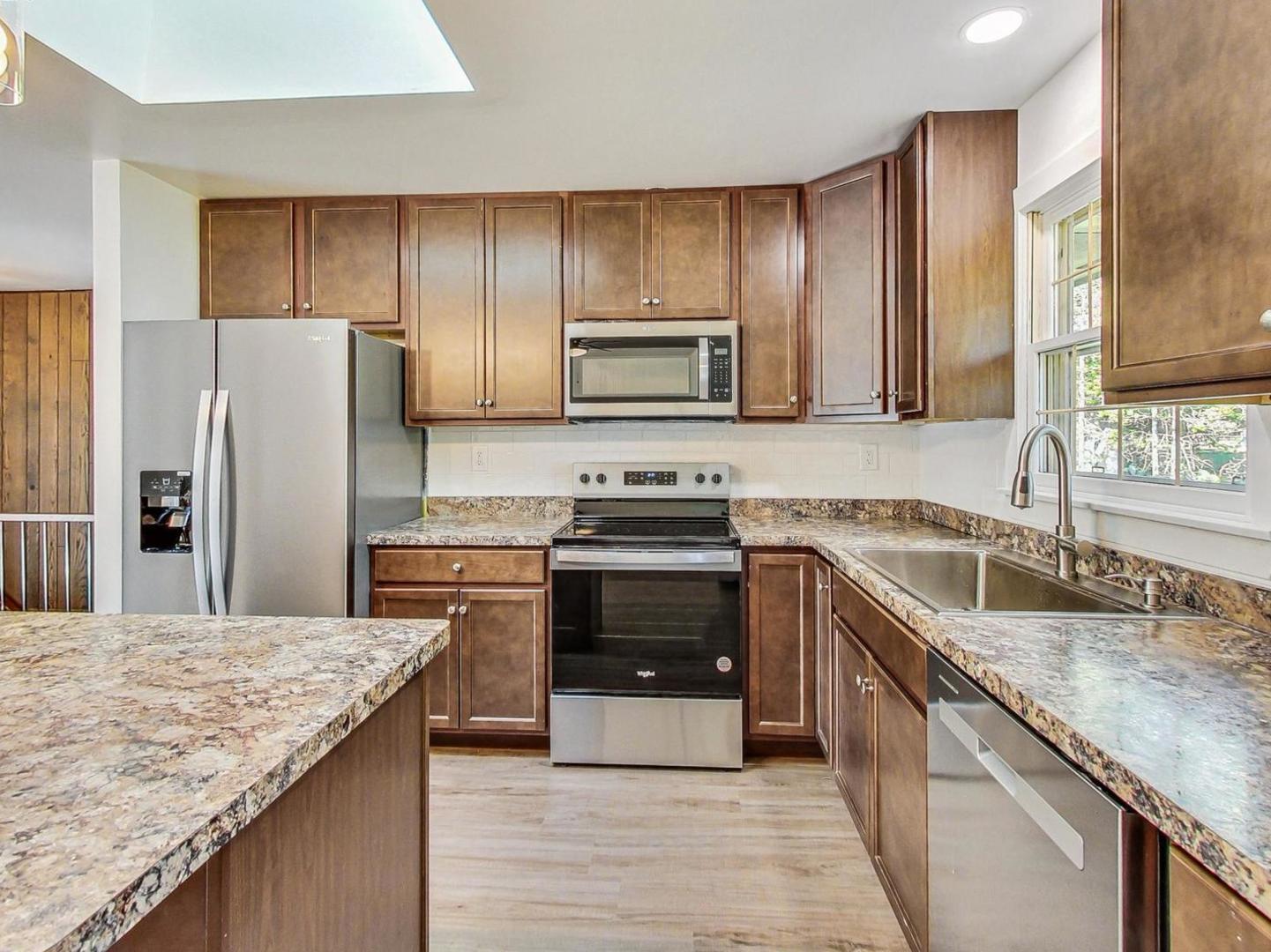 4618 William Street Johnsburg, IL 60051 - Photo 12 of 40 a kitchen with granite countertop wooden cabinets and stainless steel appliances