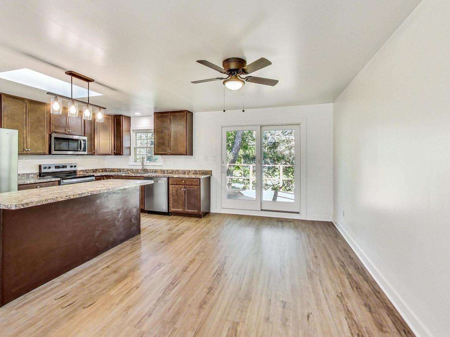4618 William Street Johnsburg, IL 60051 - Photo 7 of 40 a kitchen with stainless steel appliances a stove top oven a sink with wooden floor and cabinets