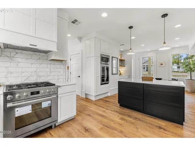 a kitchen with stainless steel appliances granite countertop a stove a refrigerator and a microwave