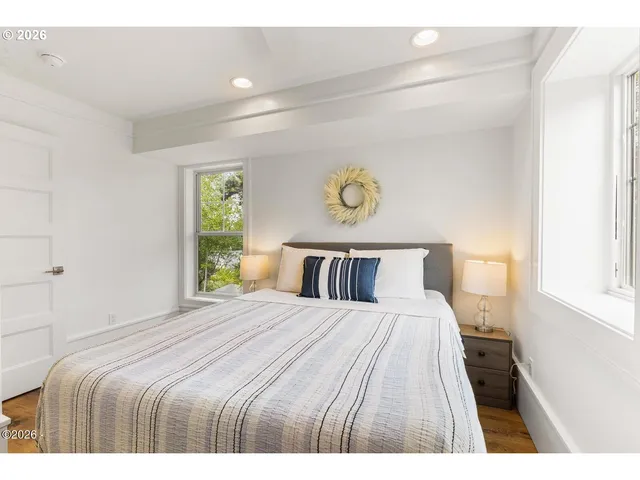 a bedroom with a bed and painting on the wall