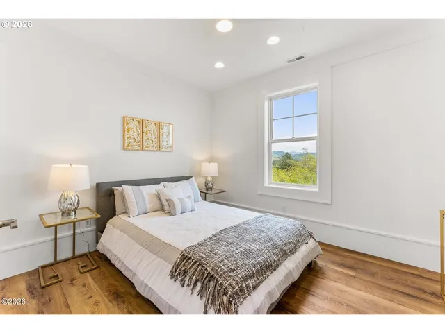 a bedroom with a bed and painting on the wall