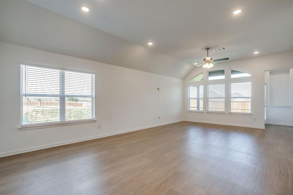 909 Schuberts Road Justin, TX 76247 - Photo 11 of 34 an empty room with wooden floor and windows