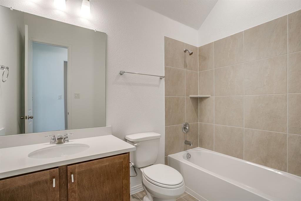 909 Schuberts Road Justin, TX 76247 - Photo 22 of 34 a bathroom with a sink a toilet and shower